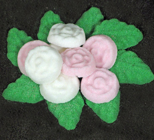 Tea sugars shaped like pink and white roses and green leaves